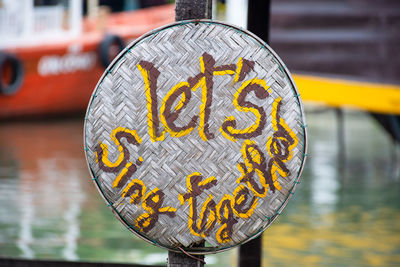 Close-up of yellow text hanging on metal