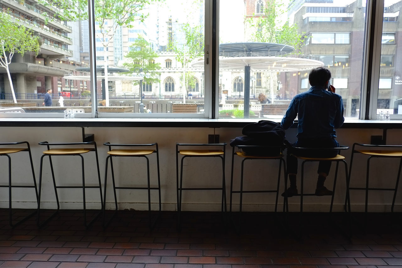 FULL LENGTH OF MAN SITTING ON WINDOW