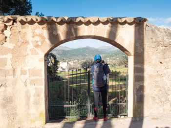 Rear view of man standing at archway