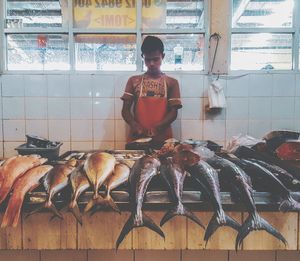 Man with fish in market stall