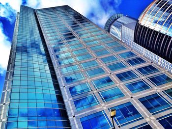 Low angle view of modern building against cloudy sky