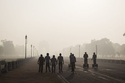 Rear view of people walking on road during foggy weather at rajpath