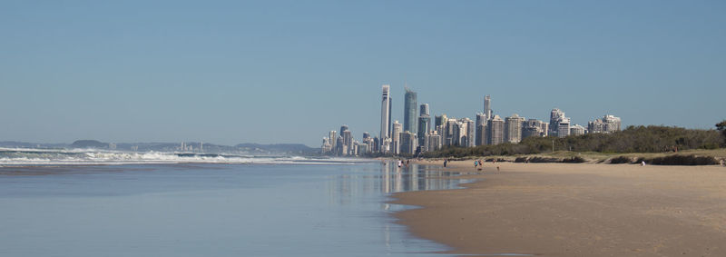 Panoramic view of sea and buildings against clear blue sky