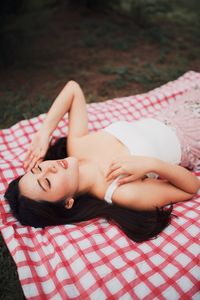 Young woman relaxing on picnic blanket