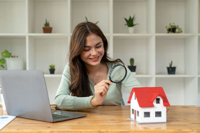 Portrait of young woman using laptop on table