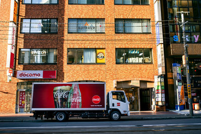 Vehicles on road against building in city