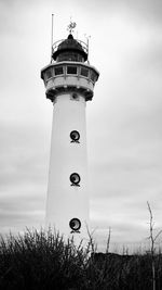 Lighthouse by sea against sky