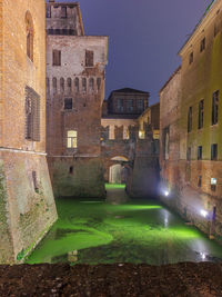 Canal amidst buildings against sky in city