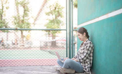 Side view of a young man using mobile phone