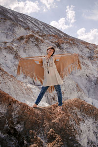 Portrait of young woman standing on rock