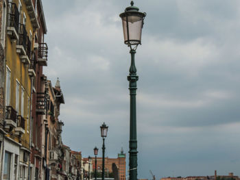 Low angle view of street light against cloudy sky