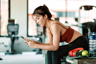 Young woman using mobile phone in building