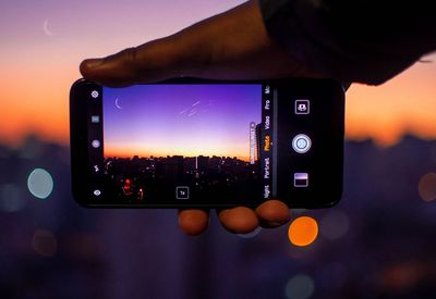 Close-up of person photographing camera on mobile phone