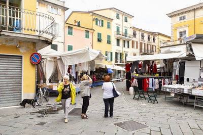 People walking on street against buildings in city