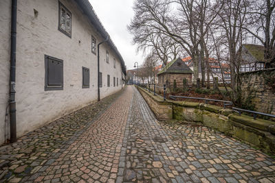 Footpath amidst houses and buildings in city