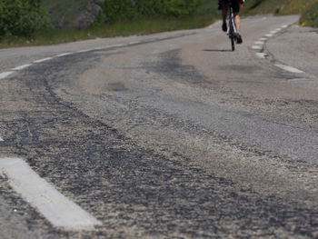 Low section of person riding bicycle on road