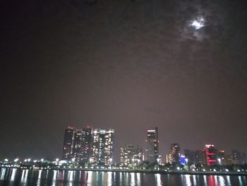 Illuminated buildings against sky at night