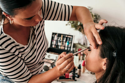 Beautician doing make-up for bride on wedding day.