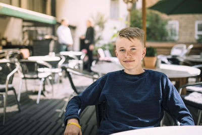 Portrait of teenage girl sitting on table