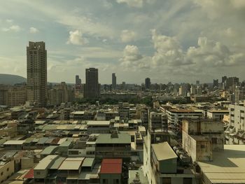 Aerial view of buildings in city against sky