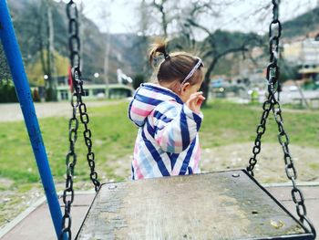 Girl walking by swing in playground