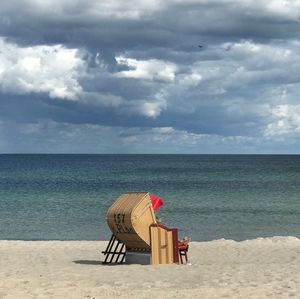 Lifeguard chair on beach against sky