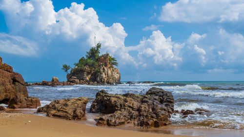 Rocks on beach against sky