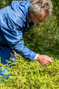 Side view of man holding plants