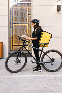 Side view of woman riding bicycle on city