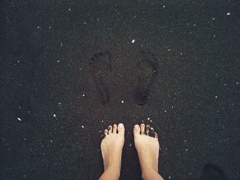 Low section of woman standing on beach