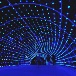 People walking in illuminated tunnel