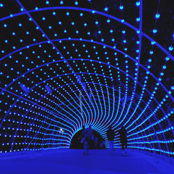 People walking in illuminated tunnel