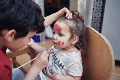 Children playing in an inner courtyard and painting with water paints