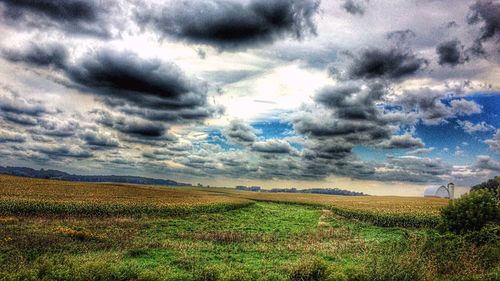 Scenic view of field against cloudy sky