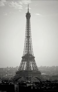 Communications tower in city against sky