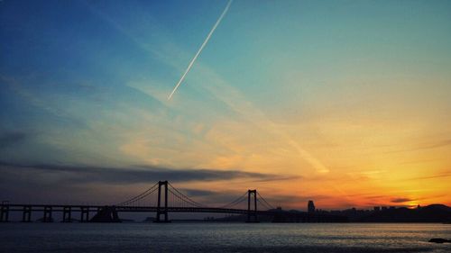 Bridge over river at sunset