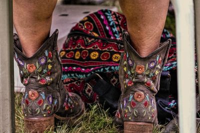 Low section of person wearing multi colored shoes