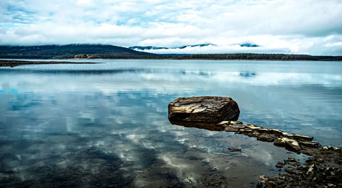 Scenic view of rocks in lake against sky