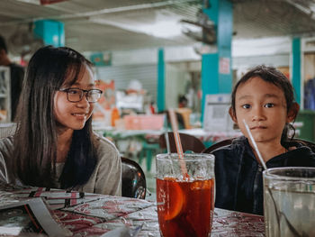 Portrait of smiling young woman sitting on table