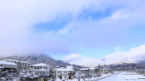 Houses against sky during winter