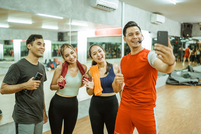 Portrait of happy friends standing in gym