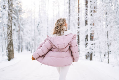 Rear view of woman standing in snow