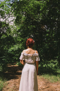 Rear view of woman standing by tree