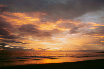 Scenic view of sea against dramatic sky during sunset