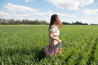 Rear view of woman standing on field