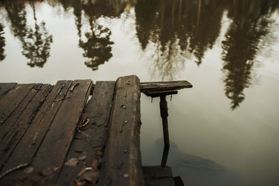 Wooden jetty on lake against sky