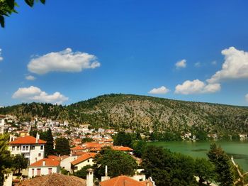 Town by mountains against blue sky