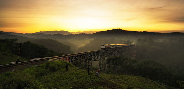 Bridge over landscape against sky during sunset