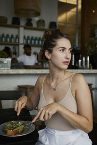 Young woman having food at table in cafe