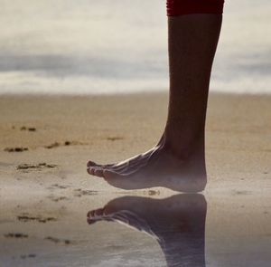 Low section of woman standing on beach